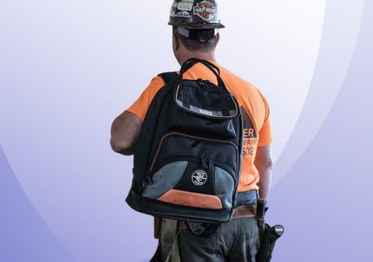 A man with a klein tool kit back pack.